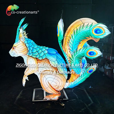 বিশাল আলোকিত কাঠবিড়ালি ভাস্কর্য লণ্ঠন যা ঝলমলে ময়ূর পালকের লেজযুক্ত